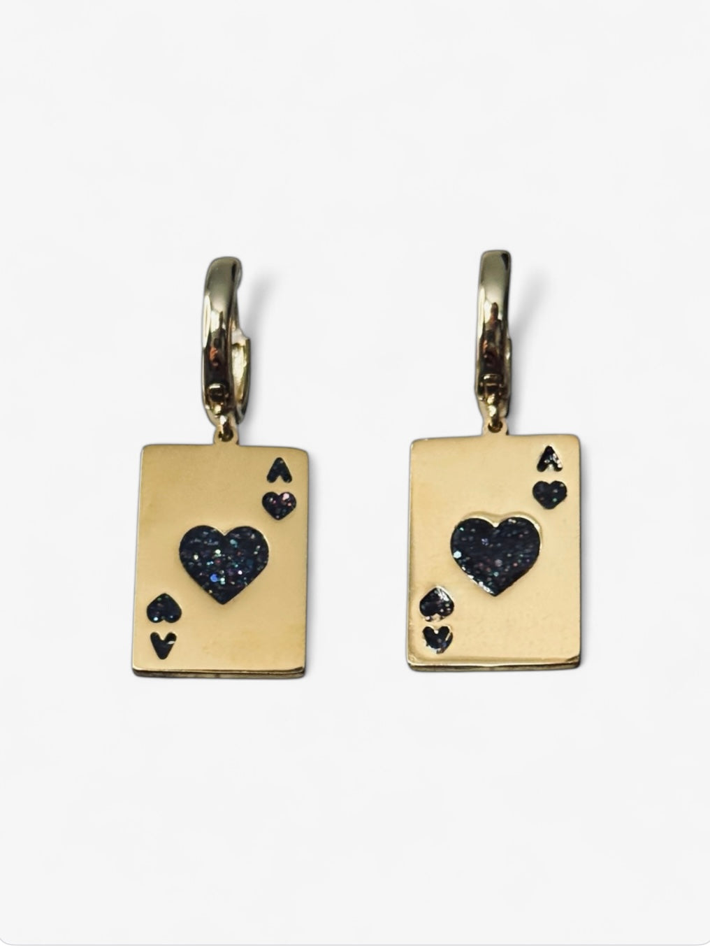 Les boucles sont posées à plat, côté face visible. On voit bien le travail des détails (petits cœurs, paillettes incrustées), et la symétrie du design. Très bon pour rassurer les clientes sur la qualité.