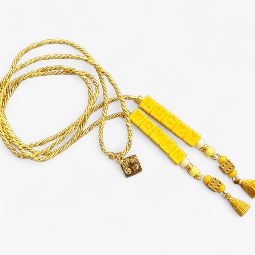 Collier Casino Club jaune soleil avec message “LUCKY WOMAN”, dés dorés, perles assorties et pompons jaunes.