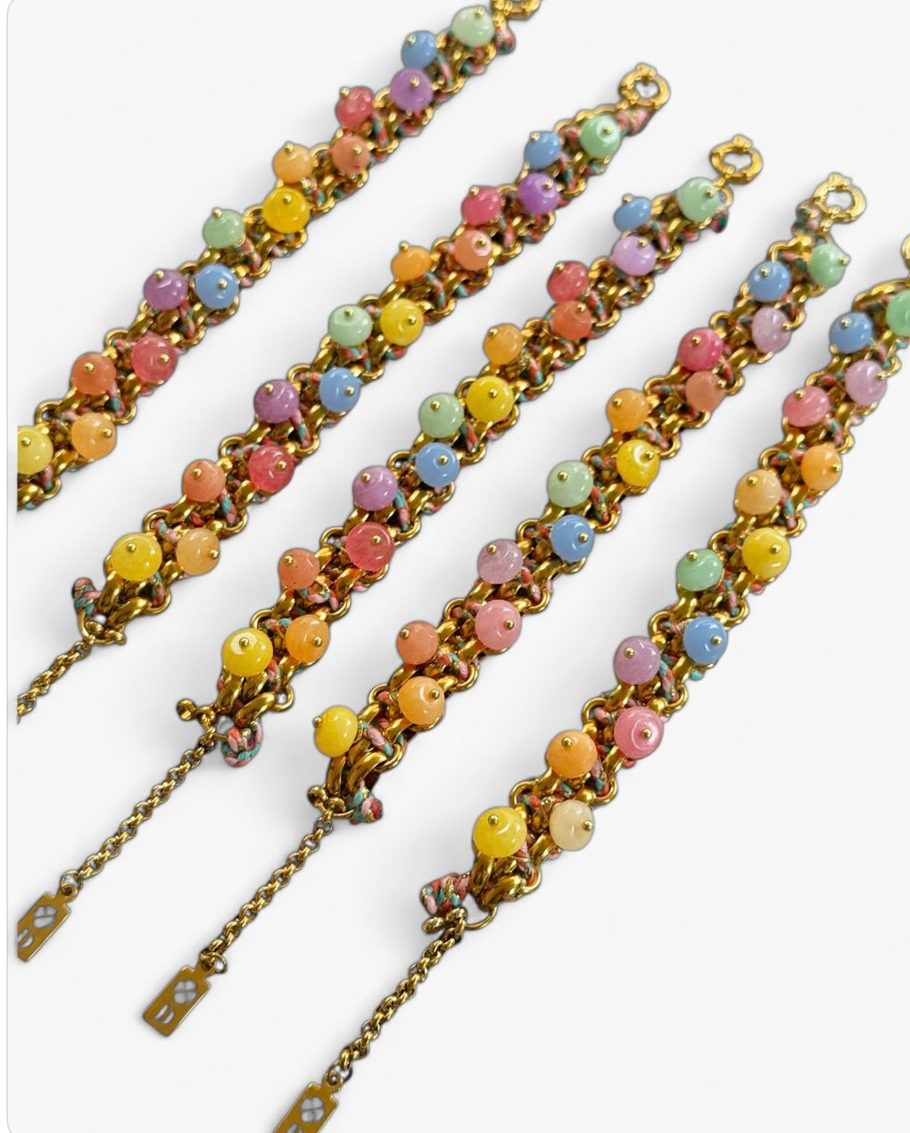 Bracelet Sugar en acier inoxydable argenté, perles semi-précieuses pastel et cordon tressé multicolore, vu de dessus avec médaille gravée.