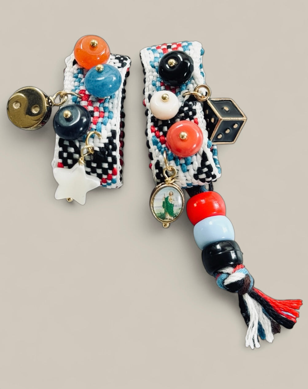 Talisman de caractère tissé en noir, blanc et rouge, la Sandalinette Chance Noire réunit breloques ludiques (smiley, étoile, dés) et pierres colorées pour un style pop mystique. Un bijou bohème et audacieux.