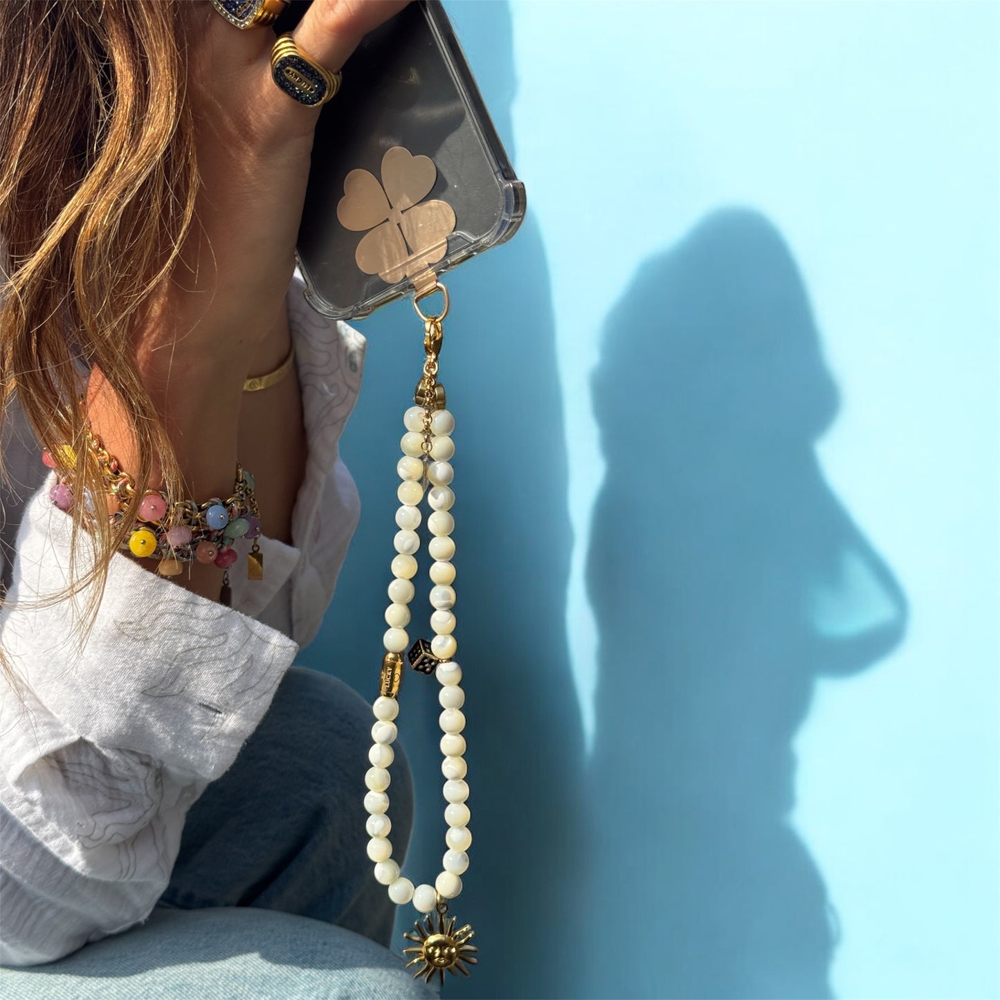 Luce porté au téléphone, dans une belle lumière naturelle. L’accessoire se transforme en bijou : à la fois utile, esthétique et symbolique. Parfait pour ajouter du style et de la spiritualité à votre téléphone.