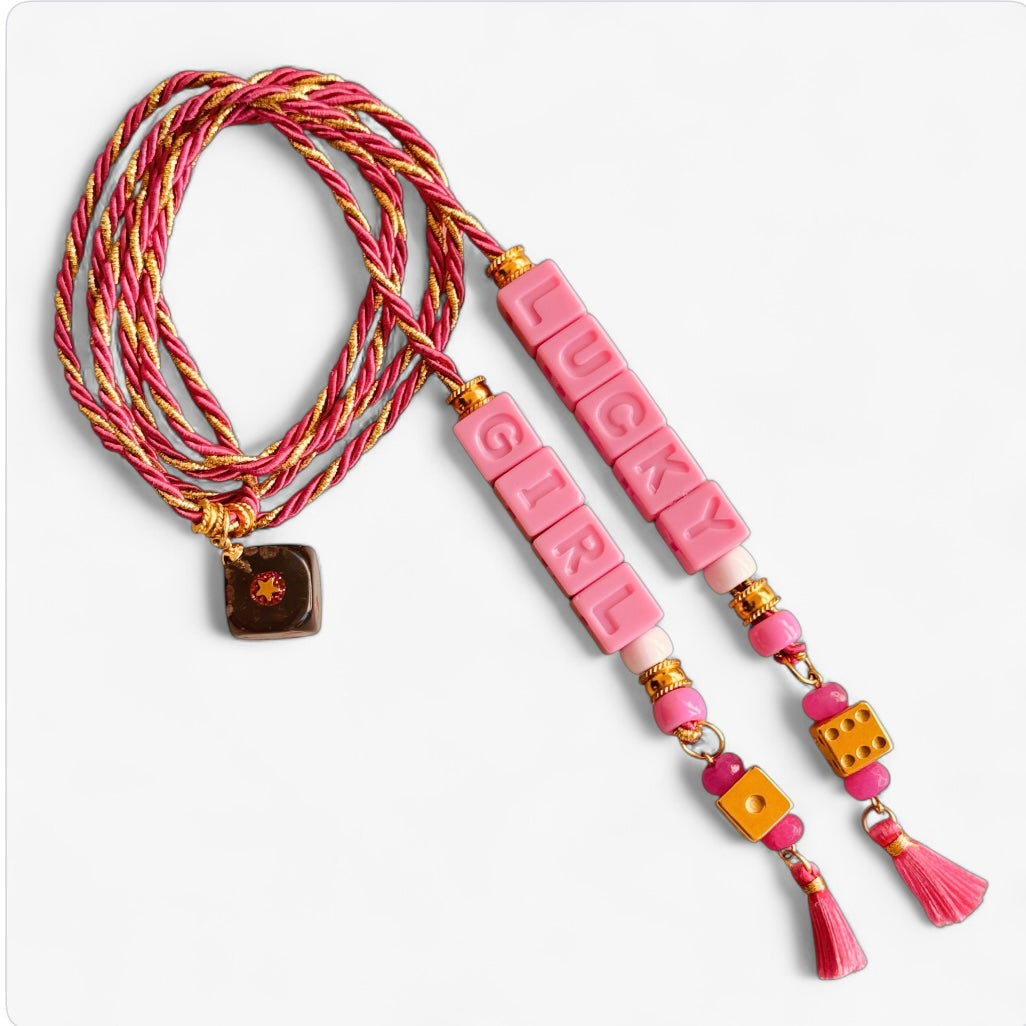 Collier Casino Club rose et doré avec message “LUCKY GIRL”, dés orange, perles roses et pampilles fuchsia.